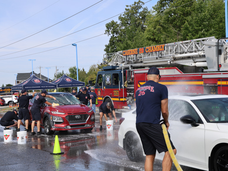 Membres du Service d'incendie qui lavent des voitures