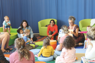 Enfants assistants à l'heure du conte, assis en cercle.