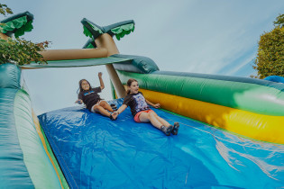 Deux enfants qui glissent sur un jeu gonflable