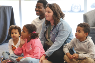 Enfants avec leurs parents, assis pour l'heure du conte.