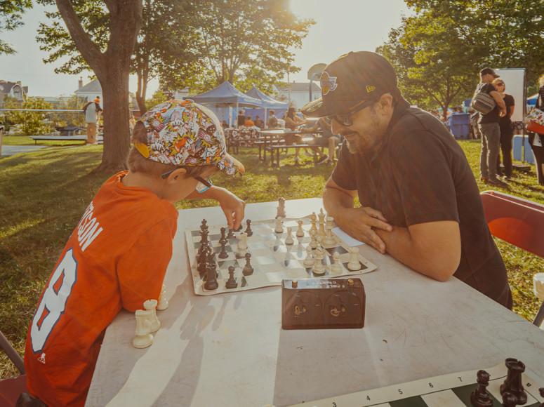 Un parent et son enfant jouent aux échecs