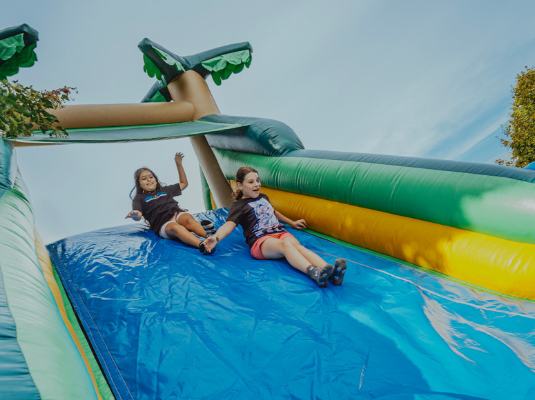 Deux enfants qui glissent sur un jeu gonflable