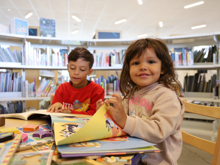 Deux enfants lisant des albums à la bibliothèque.