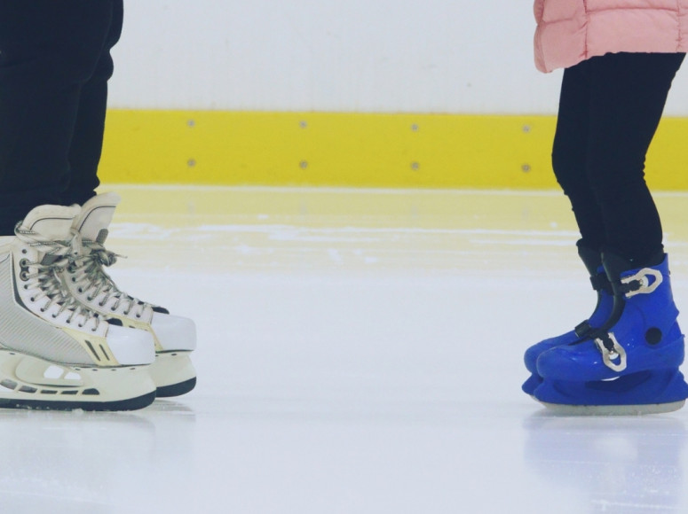 Un adulte et un enfant patinent